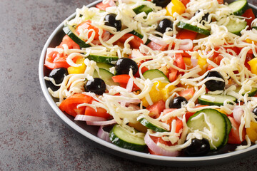 Tasty Shopska or sopska salata with vegetables and cheese closeup in the plate on the table. Horizontal