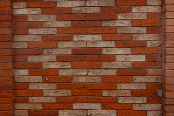 Pattern in the brick wall with light red and dark red bricks