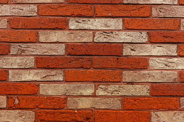 Pattern in the brick wall with light red and dark red bricks