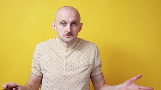 Wrong tickets. Confused man. Trip cancellation. Shocked disbelief guy with suitcase looking at passport with boarding pass yellow background.