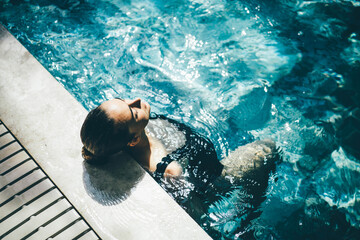 Woman relaxing in the swimming pool.