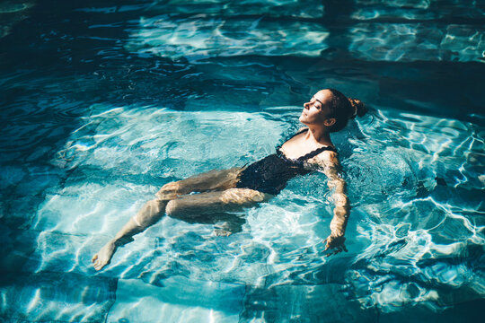 Woman relaxing in the swimming pool.