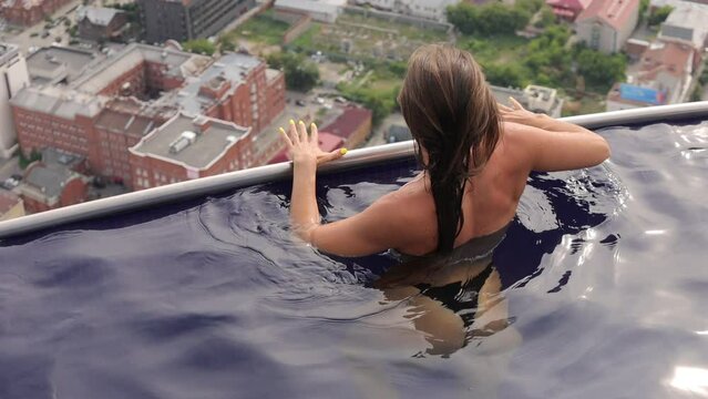 Attractive woman in swimming pool on roof