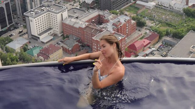 Attractive woman in swimming pool on roof