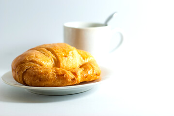 Butter croissant with a cup of coffee on white background.