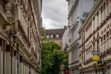 Fototapeta na wymiar Häuser in einem typischen Altstadtviertel rechts und links alte Häuser am Ende der Straße ein Baum