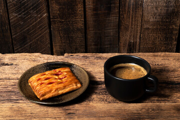 Breakfast food coffee and strawberry pie in plate on wood table.
