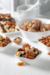 Mix of nuts and raisins on a white wooden table.