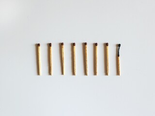 Eight matches in a row, one match burned out. The concept of burnout. Top view, white background