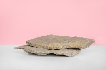 Stone Podium for promotion on pink Background. Natural pedestal. Two stone podiums. Beauty product mockup. Scene to show products. Showcase, display case. Front View, soft shadow