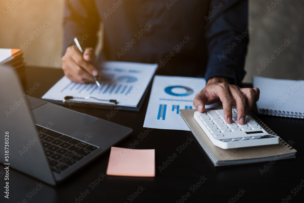 Poster close up of hands working and calculating on financial and accounting graft and chart in office spac