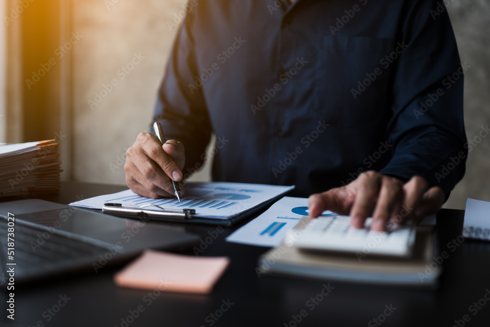 Poster close up of hands working and calculating on financial and accounting graft and chart in office spac