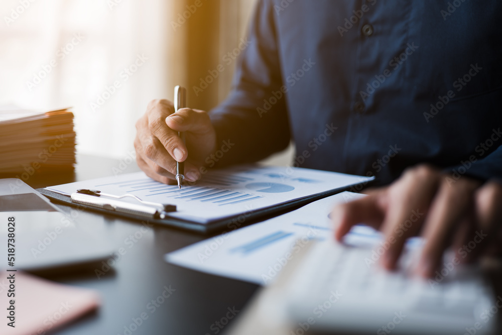 Poster close up of hands working and calculating on financial and accounting graft and chart in office spac