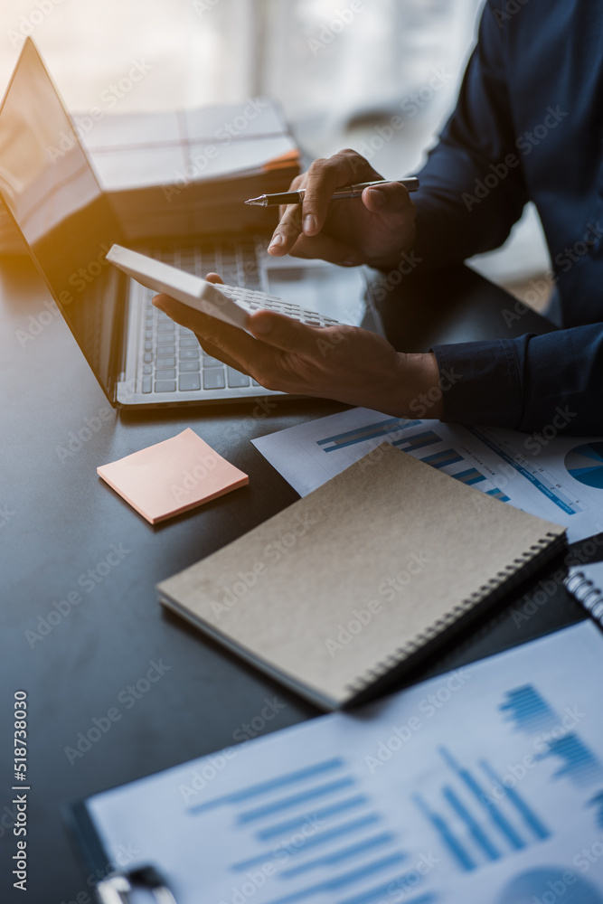 Poster close up of hands working and calculating on financial and accounting graft and chart in office spac