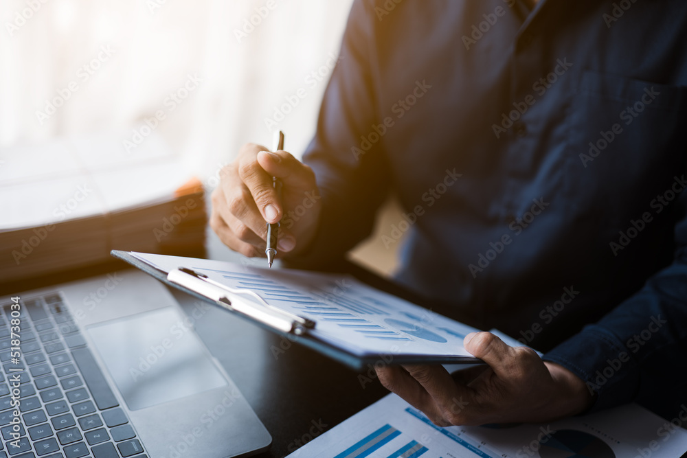 Poster close up of hands working and calculating on financial and accounting graft and chart in office spac