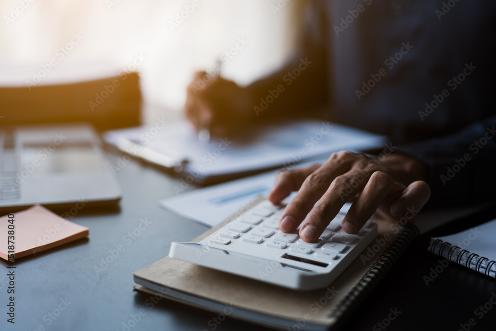 Poster close up of hands working and calculating on financial and accounting graft and chart in office spac