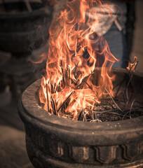 Burning incense sticks in an old stone pot at Sacred Sri Maha Bhodi Gardens close-up shot.