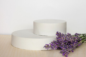 Podium for presentation on wooden table, lavender flowers. Abstract geometrical form. Cylinder...