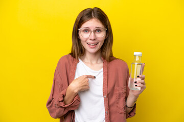 Young English woman with a bottle of water isolated on yellow background with surprise facial expression