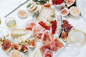 Food antipasto prosciutto ham, salami, olives and grissini bread sticks. cheese on a board...