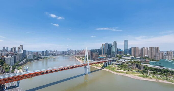 time lapse of Chongqing cityscape against a blue sky, Qiansimen bridge on Jialing river and modern architecture in central business district, China