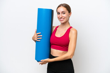 Young sport caucasian woman going to yoga classes while holding a mat isolated on white background extending hands to the side for inviting to come