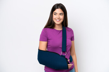 Young Brazilian woman with broken arm and wearing a sling isolated on white background looking to...