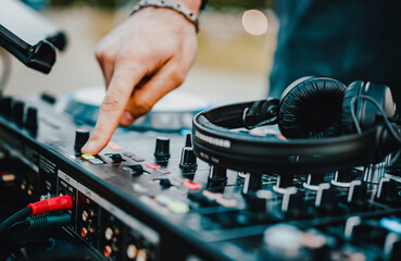 Fototapeta na wymiar DJ Hands creating and regulating music on dj console mixer in concert outdoor