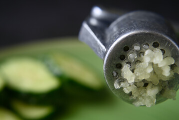 grated squeezed garlic with green cucumber. close-up. macro.