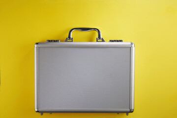 stainless steel brief case against yellow background