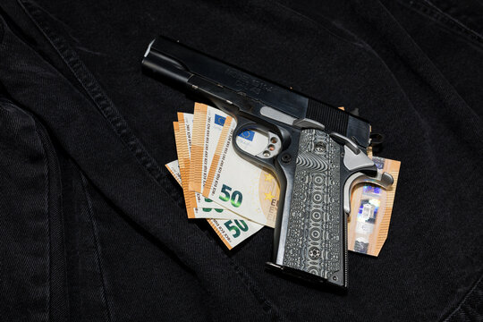 A pile of banknotes and a handgun with a decorative grip