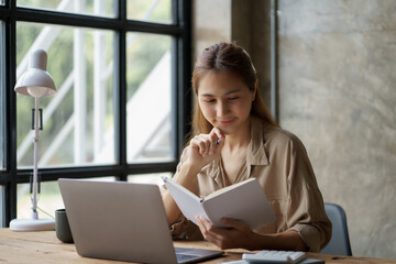 Beautiful Asian business woman sitting and smiling happy to come up with new ideas for work.