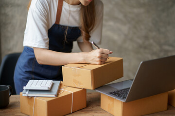 Close-up of an online business owner woman check customer lists to properly pack and ship to customers.