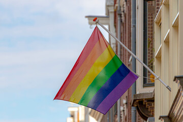 Celebration of pride in Amsterdam with rainbow flags hanging outside building along street, Symbol of Gay, Lesbian, Bisexual and Transgender, LGBT community in Holland, Social movements in Netherlands