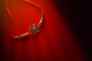 Indian festival: Raksha Bandhan. A traditional Indian wrist band on red background.