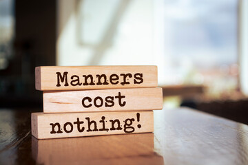 Wooden blocks with words 'Manners Cost Nothing'.