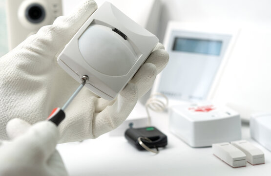 adjusting motion sensor security systems on white background.