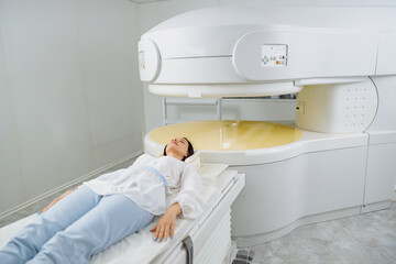 Woman patient is ready to do magnetic resonance imaging MRI or CT scan in clinic