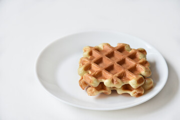 Viennese waffles on a white plate. Delicious waffles for breakfast.