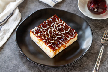 Trilece dessert. Slice of dessert with caramel and milk on a dark background. Bakery products. side view. Close-up.