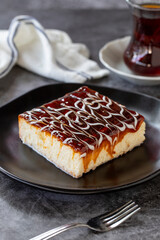 Trilece dessert. Slice of dessert with caramel and milk on a dark background. Bakery products. Vertical view. Close-up.