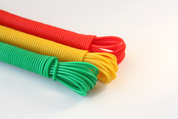 Bright rope for drying clothes on a white background. Products from multi-colored plastic. Free space for text.