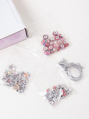 Set for сreating jewelry and box on white background. Assorted metal charms for bracelets