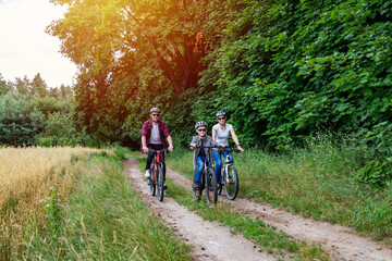 family riding a bike in the countryside at hot sunny day