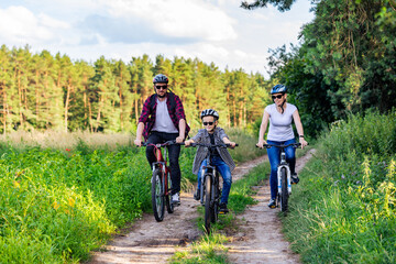 family riding a bike in the countryside at hot sunny day