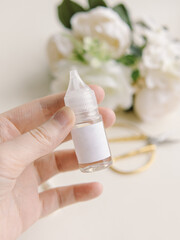Woman holds fragrance for candles and soap in a plastic bottle. Natural. Floral aroma. Liquid for electronic cigarettes and vaping