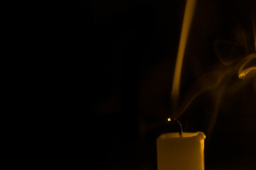 Candle extinguished to create an art smock image of smoke isolated on dark black background.