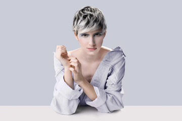 young feminin woman with grey short hair looking at camera while pose with with crossed hands next...