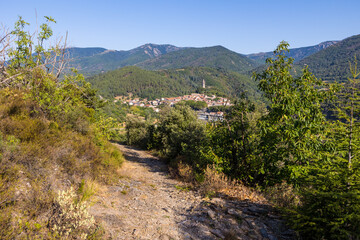 Fototapeta na wymiar Vue ensoleillée au détour d'un chemin de randonnée sur le village médiéval d'Olargues dans le Parc naturel régional du Haut-Languedoc