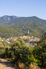 Fototapeta na wymiar Vue ensoleillée au détour d'un chemin de randonnée sur le village médiéval d'Olargues dans le Parc naturel régional du Haut-Languedoc